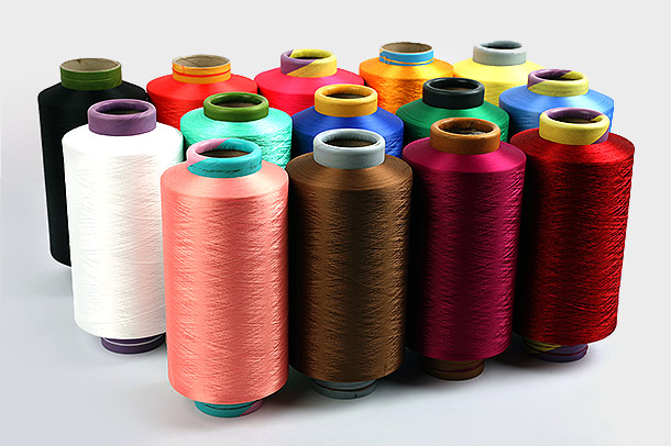 Apa keuntungan utama menggunakan Benang Poliester DTY dalam aplikasi tekstil, dan bagaimana proses produksinya berkontribusi terhadap popularitas dan penggunaannya secara luas dalam industri tekstil?